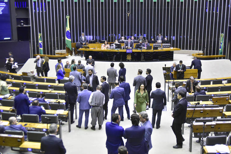 Plenário está em parte vazio, com alguns deputados conversando em pé