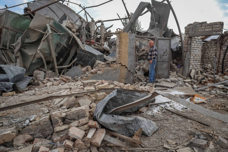 Fazendeiro ucraniano ao lado de depósito de grãos destruído pelos russos em Zaporíjia (sul)