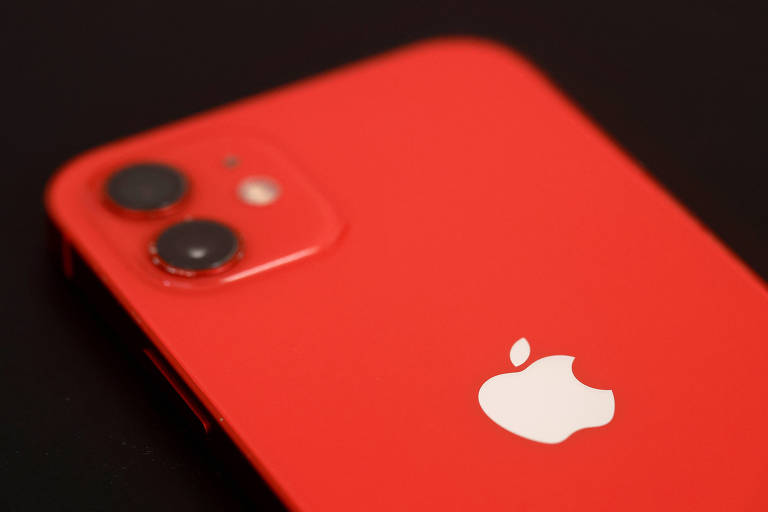 iPhone 12 foi lançado em outubro de 2020, com sistema operacional de três gerações atrás. Aparelho estava em exposição em vitrine em Nantes, França. Smartphone tem acabamento vermelho.