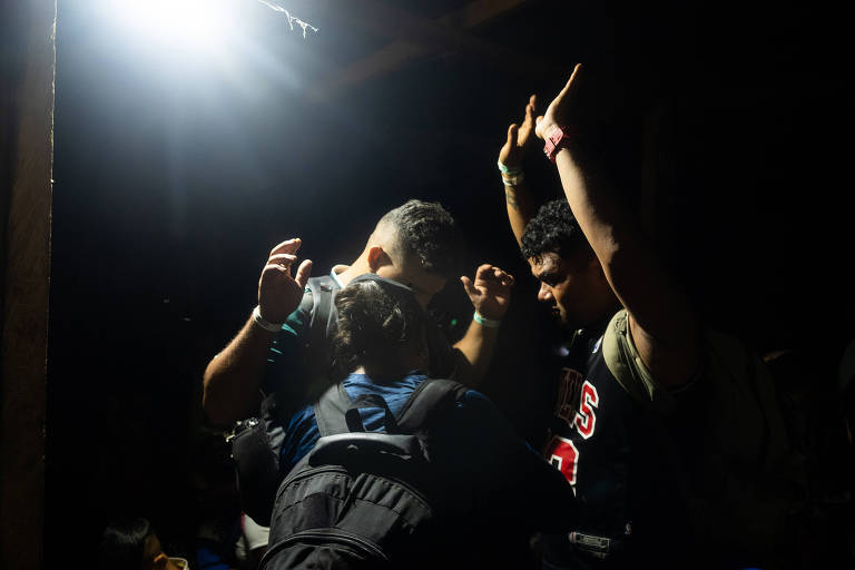 Migrantes rezam antes de começaram o caminho no estreito de Darién