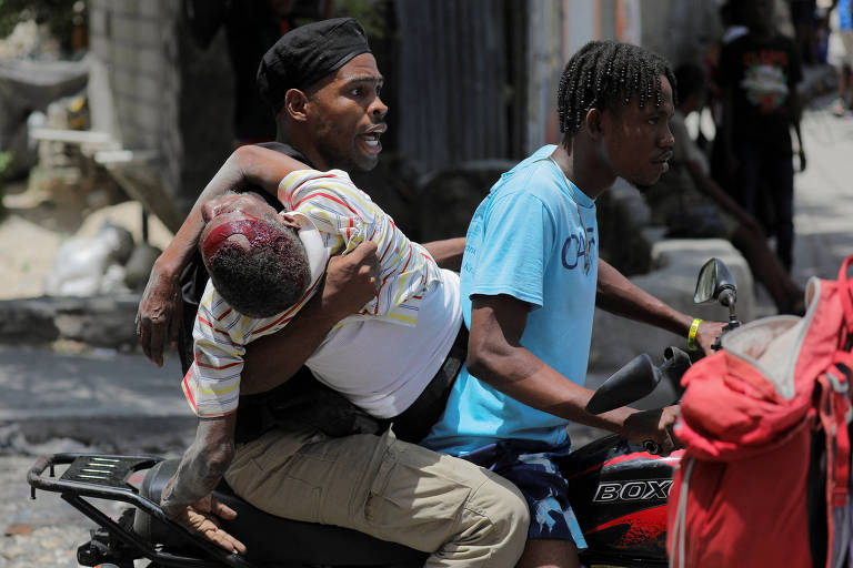 Moradores carregam em moto homem ferido após ação de gangues em Carrefour Feuilles, na capital do Haiti, Porto Príncipe