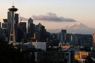 A general view shows the Space Needle and Mount Rainier at sunrise in Seattle