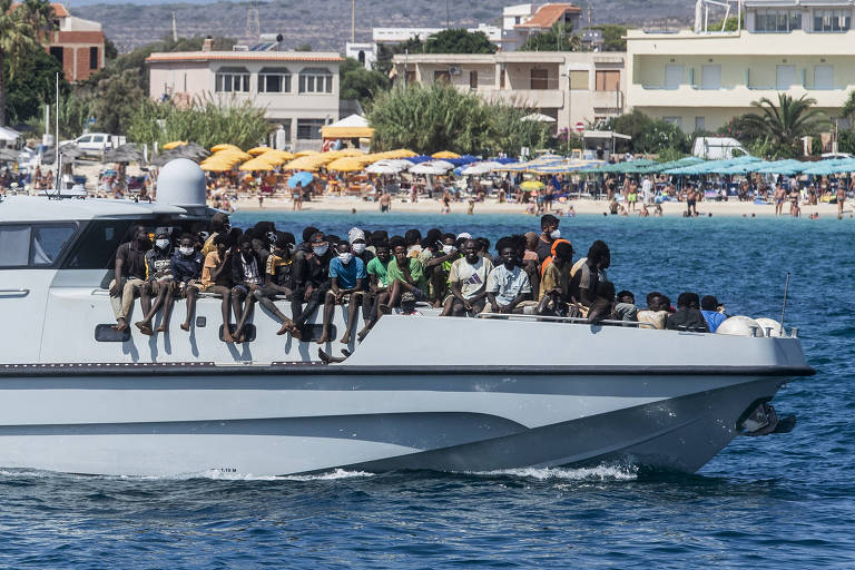 Imigrantes resgatados no mar são levados pela Guarda Costeira até a costa da ilha de Lampedusa