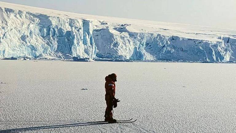 Cientista em pé sobre o gelo na Antártida
