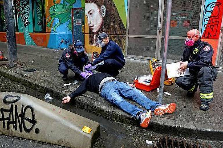 Pessoa em overdose é atendida por médicos nas ruas de Vancouver, Canadá