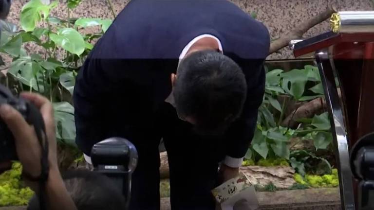 Após anunciar sua demissão, o ministro taiwanês da Agricultura, Chen Chi-chung, se curva diante das câmeras