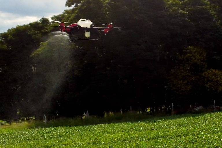 Imagem mostra drone dispersando agrotóxico em plantação