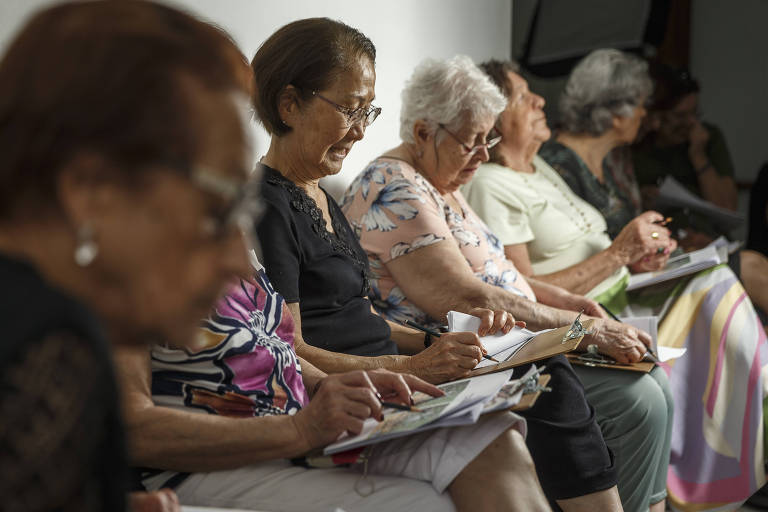 Mulheres aposentadas escrevem em seus cadernos