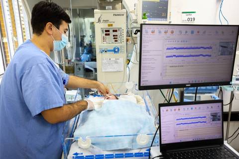 Médico faz monitoramento encefálico de recém-nascido, em UTI neonatal de um dos cinco hospitais municipais de São Paulo que adotaram essa tecnologia 