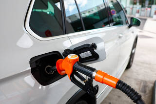 A diesel fuel nozzle fills up the tank of a car at a petrol station in Paris
