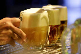 FILE PHOTO: A bartender prepares glasses of beer in Prague