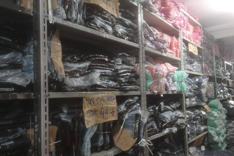 Imagem mostra estoque cheio com roupas de inverno acumuladas na loja de jeans Dejelone, no Brás