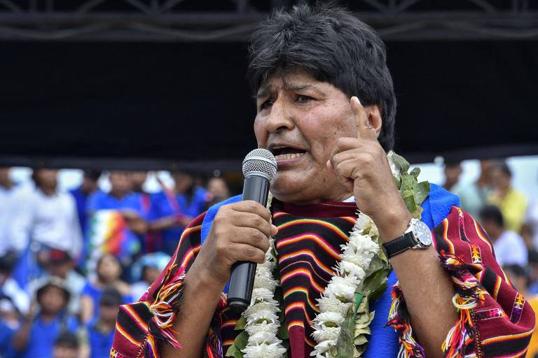 Homem indígena boliviano com vestes tradicionais fala ao microfone