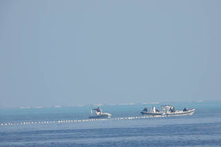 Chinese Coast Guard boats close to the floating barrier are pictured near the Scarborough Shoal