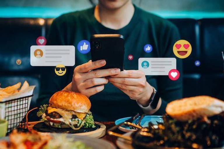 Homem usa celular para filmar comidas e postar nas redes sociais