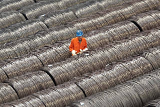 FILE PHOTO: A worker checks steel wires at a warehouse in Dalian, Liaoning province