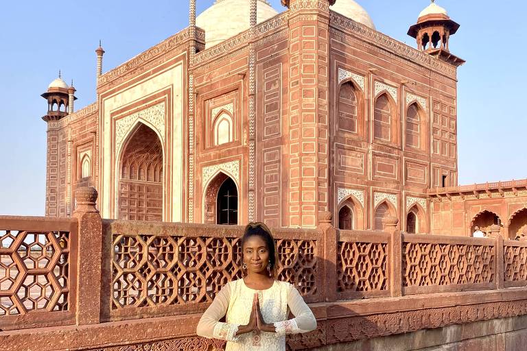 Mulher negra em frente a templo religioso durante viagem de volta ao mundo