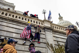 Protestors climb the Capitol in Washington on Wednesday, Jan. 6, 2021. (Jason Andrew/The New York Times)