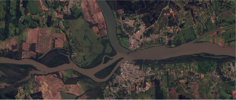 imagem de satélite mostra cidade antes de chuva, com rio passando ao meio e casas e vegetação no entorno