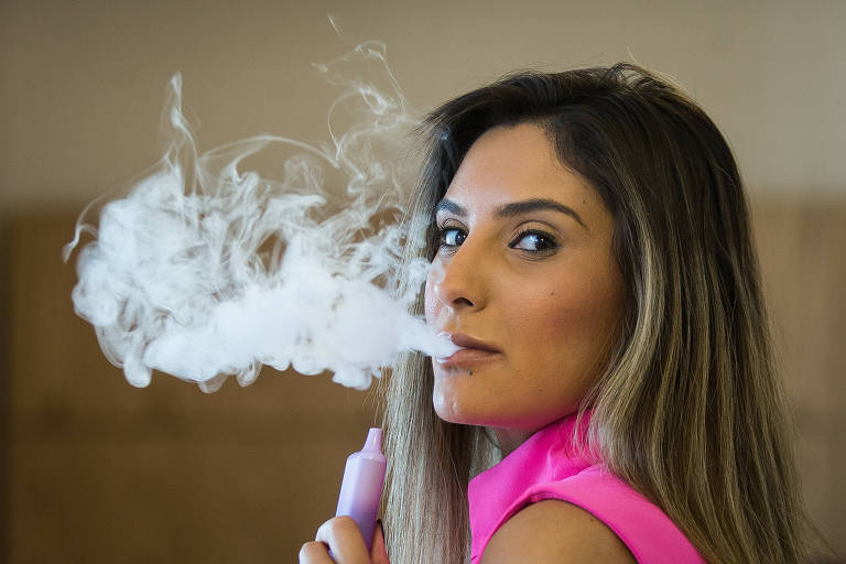 Priscila Farias, 30, passou a usar o cigarro eletrônico no ano passado e relata que usa o dispositivo o dia inteiro