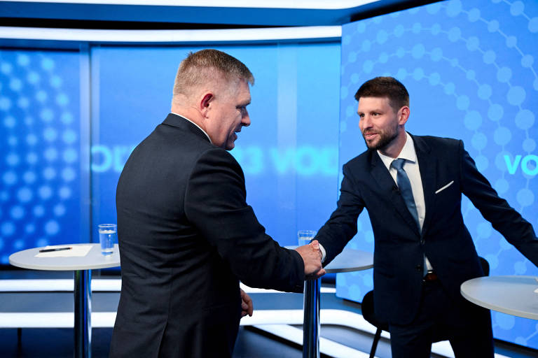Robert Fico (esq.) cumprimenta Michal Simecka, líder do partido rival PS, durante debate na TV eslovaca na terça (26)