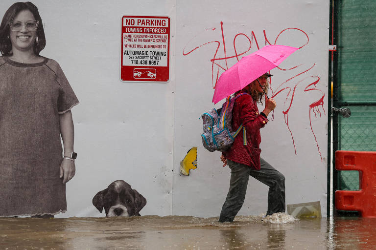 Mulher caminha em rua alagada no Brooklyn, em Nova York