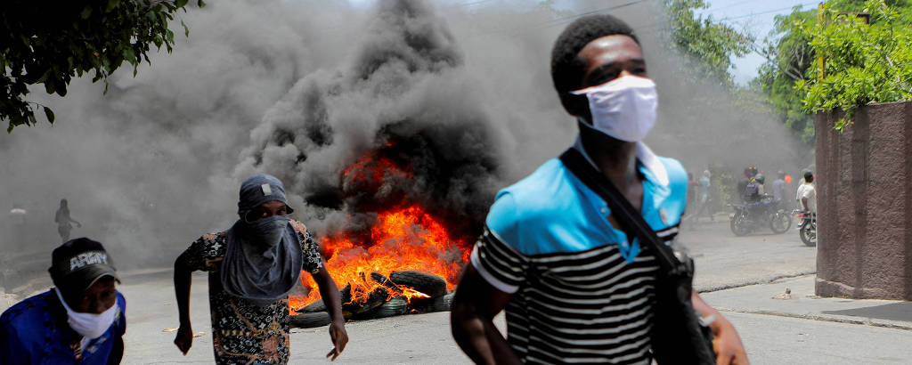 Homens correm durante protesto contra a violência de gangues no Haiti