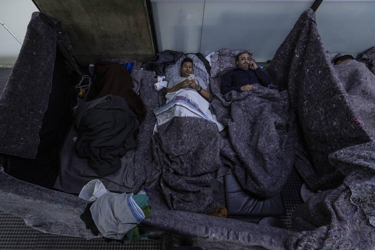 Afegãos deitados em tendas improvisadas no Terminal 2 do Aeroporto Internacional de São Paulo, em Guarulhos