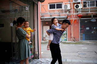 FILE PHOTO: Sun Yan, 25, and her husband play with their two children on the outskirts of Shanghai