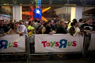 People line up outside a Toys R Us store just before midnight to purchase toys in advance of the film 