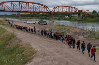 Migrants from Venezuela surrender along bank of Rio Grande river in Eagle Pass