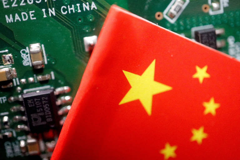 Bandeira da China é colocada na frente de circuito de computador com a mensagem "Feito na China"