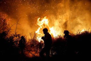 Firefighters work to put out a fire in an open field, following a mass-infiltration by Hamas gunmen from the Gaza Strip, near a hospital in Ashkelon, southern Israel