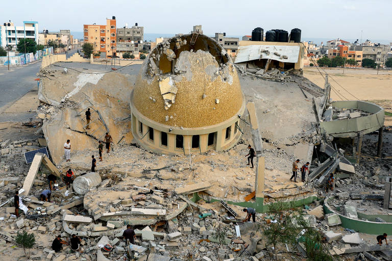 Palestinos inspecionam mesquita destruída em ataques israelenses em Khan Younis, no sul da Faixa de Gaza