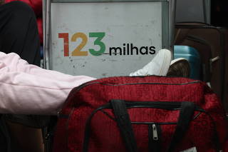 Cartaz da 123Milhas em carrinho de malas do Aeroporto de Congonhas