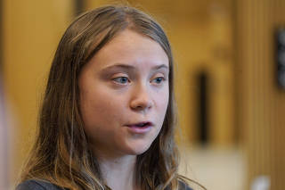 Swedish climate activist Greta Thunberg waits outside a room in Malmo district court.