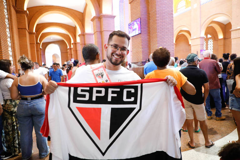 Homem levanta faixa com o símbolo do São Paulo FC