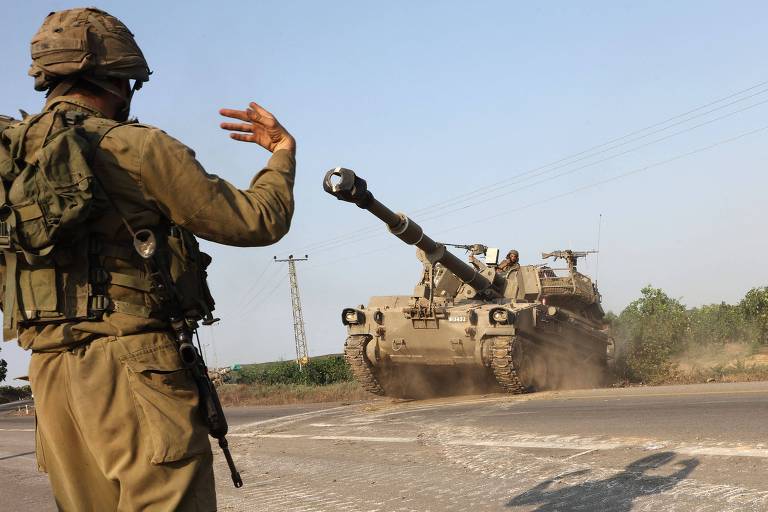 Militar de Israel sinaliza para ajudar na movimentação de tanque do país após ataques do Hamas