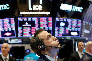 FILE PHOTO: A trader works on the floor of the New York Stock Exchange shortly before the closing bell as the market takes a significant dip in New York