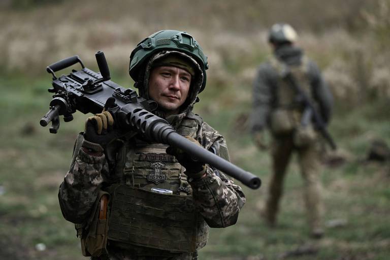 Soldado ucraniano carrega uma metralhadora Browning M2 durante treino tático em Donetsk