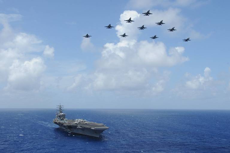 Caças F-18 sobrevoam o porta-aviões USS Dwight D. Eisenhower, que será enviado para Israel