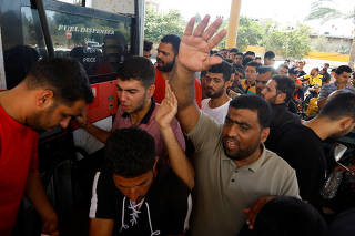 Palestinians queue to get fuel from a petrol station in Khan Younis