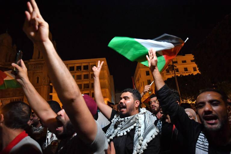 Manifestantes protestam contra Israel e Estados Unidos e agitam bandeiras da Palestina em frente à embaixada francesa em Túnis, capital da Tunísia