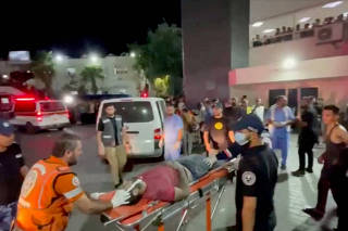 Injured people are taken into hospital after hundreds of Palestinians were killed in a blast at Al-Ahli hospital in Gaza that Israeli and Palestinian officials blamed on each other