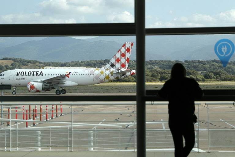Passageiro observa aeronave na pista em aeroporto frances