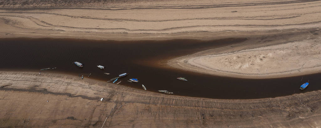 Vista de drone das canoas em trechos do rio cercados por areia