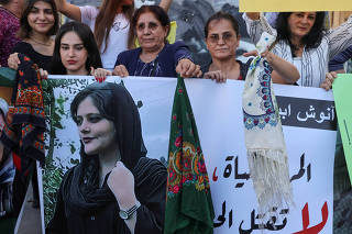 FILE PHOTO: Women hold a picture of Mahsa Amini during a sit-in following her death, at Martyrs' Square in Beirut