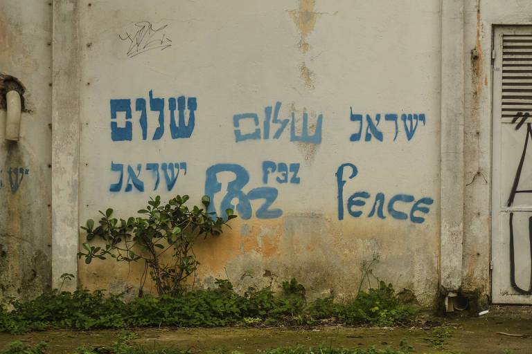 Sinais da guerra em São Paulo. Muro com inscrições em hebraico, português e inglês, onde se lê a palavra "paz", no bairro de Higienópolis