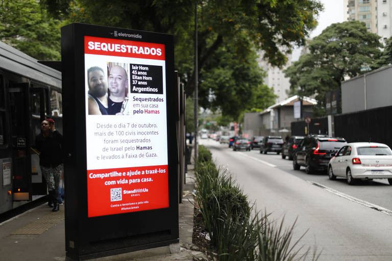 Cartazes em um totem publicitário na Av. Cidade Jardim próximo a Faria Lima de pessoas procuradas que foram sequestradas pelo Hamas no conflito de Israel