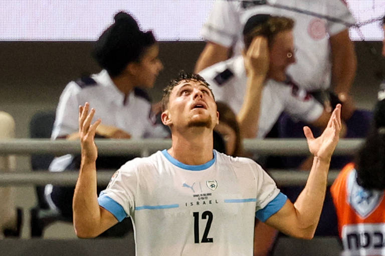 Usando camisa branca com o número 12 na altura do peito, Gavriel Kanichowsky, de Israel, comemora com os braços abertos e olhando para o alto seu gol, o único do jogo contra a Belarus em Tel Aviv pelas Eliminatórias da Eurocopa de 2024